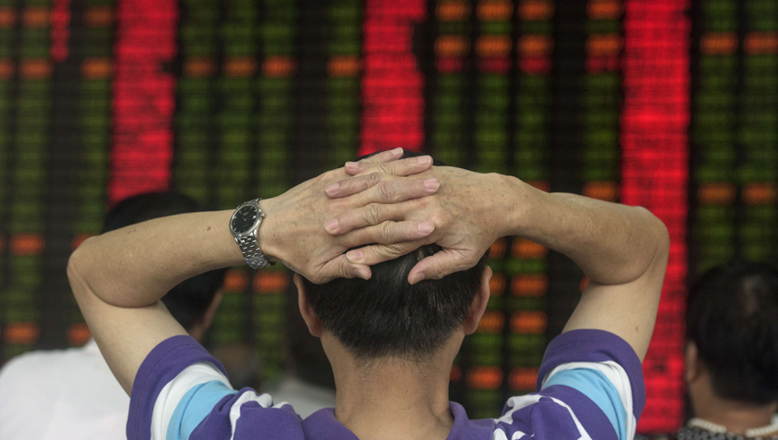 Investors react in front of screens showing stock market movements at a brokerage house in Shanghai on Tuesday. Asian stocks sank after more data showed weakness in China's economy, while gold and the yen advanced amid a search for safer assets, sending Tokyo tumbling almost 4 per cent (AFP photo)