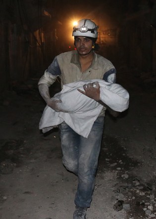 A Syrian rescuer carries the body of a baby following a government air strike on a rebel held sector of the northern Syrian city of Aleppo late on Wednesday (AFP photo)