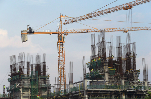 Construction workers build a high rise commercial residential project at a business district in Manila on Tuesday (Reuters photo)