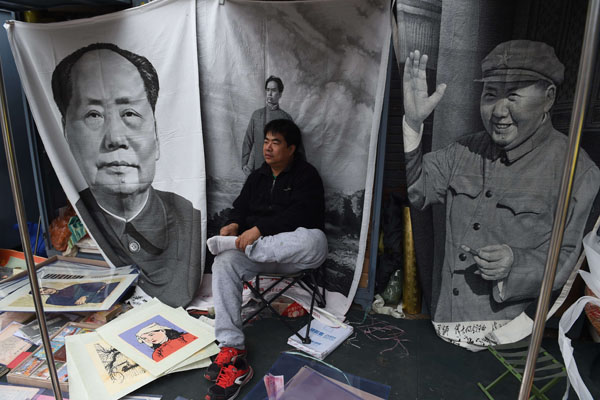 A vendor waits for customers for wall hangings of late communist leader Mao Zedong at a market in Beijing on Sudnay. China's leaders will gather on Monday to hash out a new five-year plan to battle slowing growth, and analysts say they must choose between chasing a traditional GDP target and embracing reforms such as to the ‘one-child policy’ to help the country develop its full potential (AFP photo)