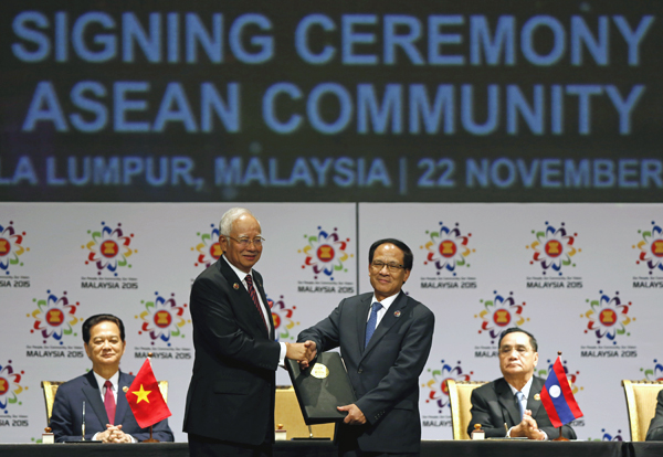 Malaysian Prime Minister Najib Razak (centre left) passes a signed document to ASEAN Secretary General Le Luong Minh (centre right) of Vietnam after the signing ceremony of the 2015 Kuala Lumpur Declaration on the Establishment of the Association of Southeast Asian Nations (ASEAN) Community and the Kuala Lumpur Declaration on ASEAN 2025, in Kuala Lumpur, on Sunday. Seated behind are: Vietnam's Prime Minister Nguyen Tan Dung (left) and Laos' Prime Minister Thongsing Thammavong (AP photo)
