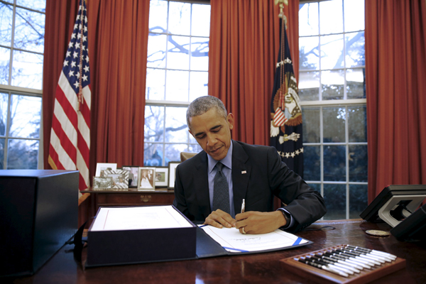US President Barack Obama signs the $1.1 trillion government funding bill into law at the Oval Office at the White House in Washington on Friday (Reuters photo)