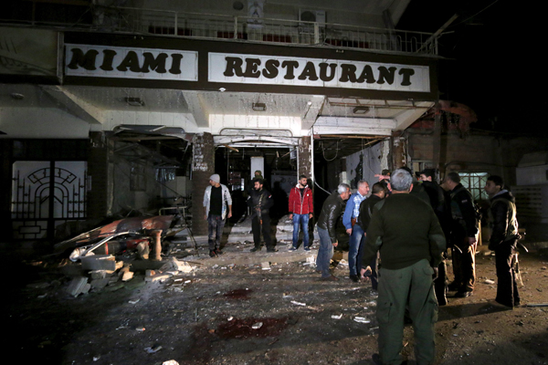 Residents inspect damage from a suicide bomb in Qamishli, Syria, on Wednesday (Reuters photo)