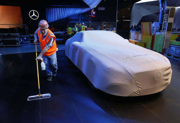 Carpenter Andy Assenmacher cleans the floor at the Mercedes-Benz exhibit in preparation for the upcoming North American International Auto Show in Detroit, on Thursday (AP photo)