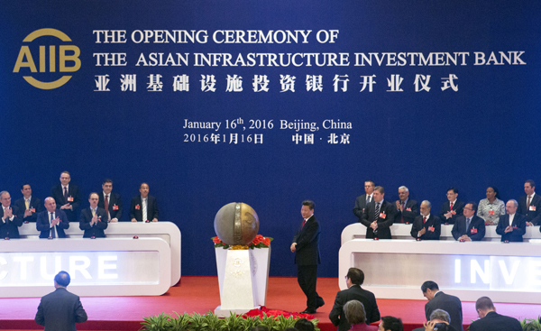 Representatives of the founding nations of the Asian Infrastructure Investment Bank (AIIB) applaud as Chinese President Xi Jinping (centre) unveils a sculpture during the opening ceremony of the AIIB in Beijing, on Saturday (AP photo)
