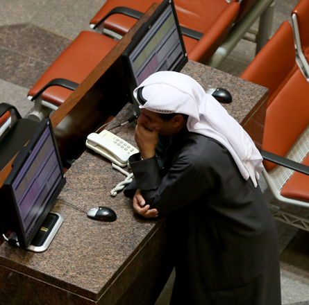 A Kuwaiti trader follows the stock market activity at the Kuwait Stock Exchange in Kuwait City, on Sunday (AFP photo)