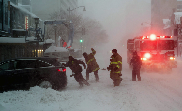 Firefighter help push a stuck car after a snowstorm on Saturday in Washington, DC (AFP photo)