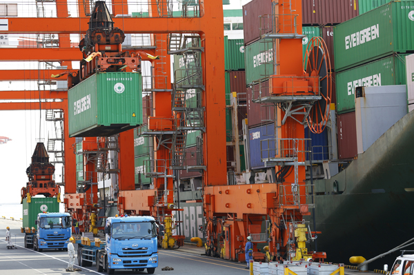 In this October 21, 2015, file photo, workers watch shipping and discharging of containers at a port in Tokyo (AP photo)
