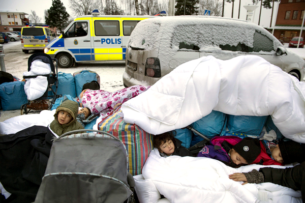 In this January 8 file photo, migrant children Nor, Saleh and Hajaj Fatema from Syria sleep outside the Swedish Migration Board in Marsta, Sweden (AP photo)