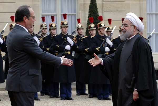 French President Francois Hollande (left) greets Iranian President Hassan Rouhani before a meeting at the Elysee Palace, in Paris, on Thursday (AP photo)