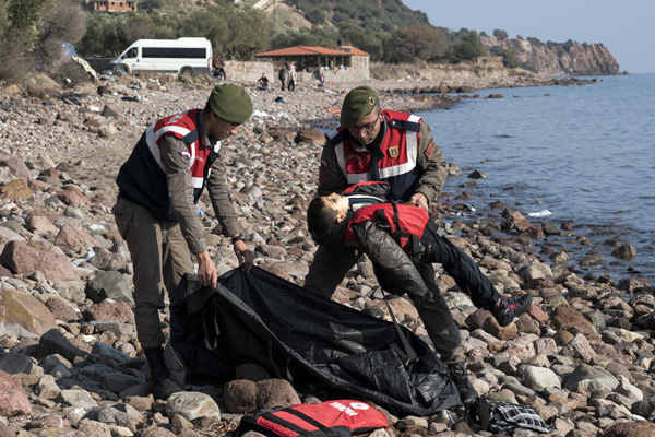 A Turkish paramilitary police officer holds the lifeless body of a migrant boy near the Aegean town of Ayvacik, Canakkale, Turkey, on Saturday (AP photo)