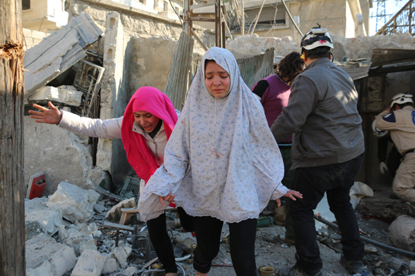Syrian girls react following a reported Syrian regime air strike in a rebel-controlled area in the northern city of Aleppo, on Monday (AFP photo)