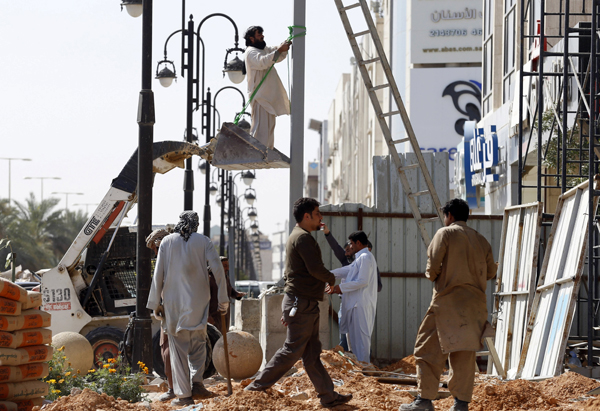 A labourer works to remove a pole outside a residential building in Riyadh, on Tuesday (Reuters photo)