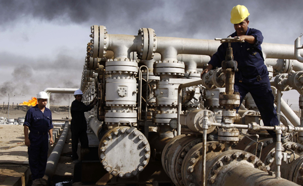 Iraqi workers are seen at the Rumaila oil refinery, near the city of Basra 550km southeast of Baghdad, Iraq (AP file photo)