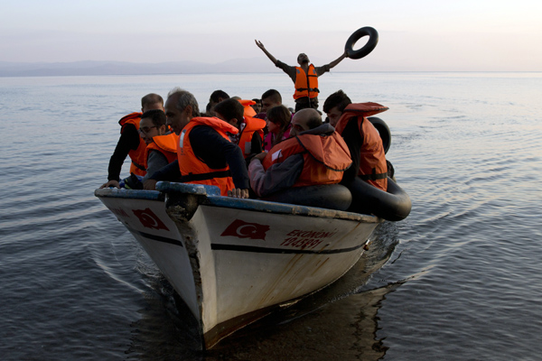 In this photo taken on September 27, 2015, a Syrian refugee thanks God as he arrives with others from Turkey on the shores of the Greek island of Lesbos (AP photo)