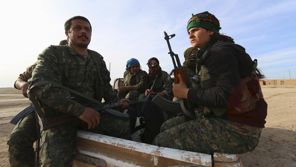 Fighters from the democratic forces of Syria carry their weapons on the back of a pick-up truck in Ghazila village after taking control of the town from Daesh militants in the southern countryside of Hasakeh, Syria, on Wednesday (Reuters photo)