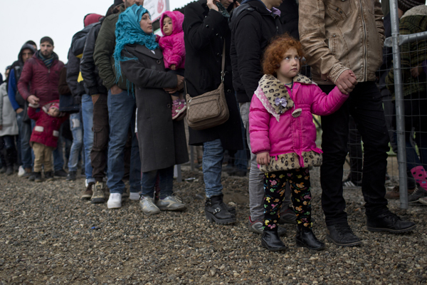Refugees stand in queue to receive food distributed by a non-governmental organisation at a refugee camp near the northern Greek village of Idomeni, on Wednesday (AP photo)