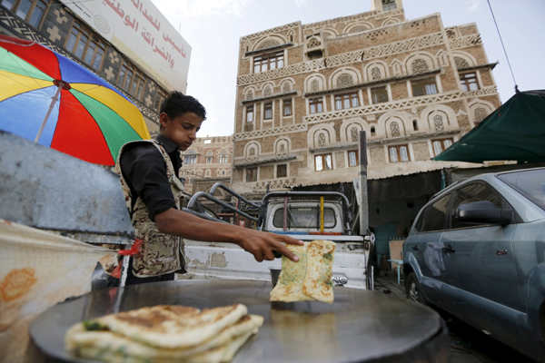 A food vendor works in his roadside stall as he waits for customers in Yemen's capital Sanaa, on Thursday (Reuters photo)