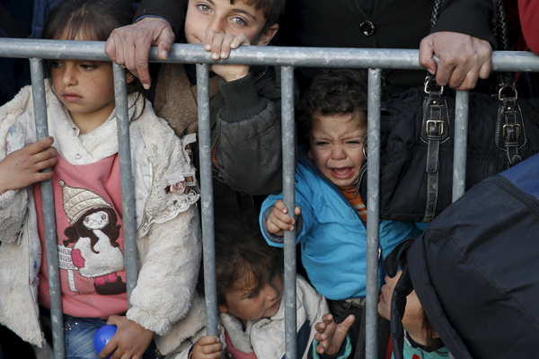 Migrants wait to cross the border between Greece and the Former Yugoslav Republic of macedonia at a makeshift camp, near the village of Idomeni, Greece, on Saturday (Reuters photo)