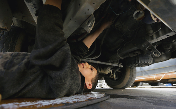 Syrian Othman Al Najjar, 12, works at a mechanic shop, which is located underneath a room he lives in with the rest of their family members, in the capital damascus, on Thursday (AFP photo)