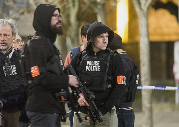 Police officers secure an area during an apartment raid in Brussels on Tuesday (AP photo)
