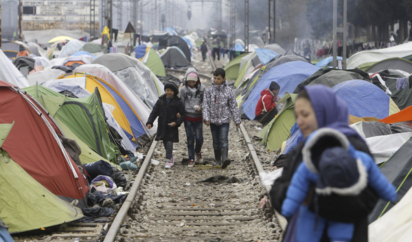Refugee children walk along railway tracks at a makeshift migrant camp in the northern Greek border post of Idomeni, on Thursday (AP photo)