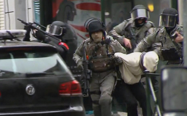 In this framegrab taken from VTM, armed police officers escort a suspect to a police vehicle during a raid in the Molenbeek neighbourhood of Brussels, Belgium, on Friday (AP photo)