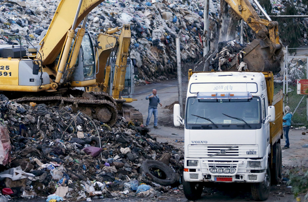 Workers in Beirut use a front-loader to move garbage to Naameh landfill, south of Beirut, Lebanon, on Saturday (Reuters photo)