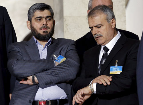In this March 15, 2016 file photo, Asaad Al Zoubi (right) of the High Negotiations Committee looks at his watch next to Mohamed Alloush of the Jaysh Al Islam during a news conference after a meeting with UN mediator for Syria Staffan de Mistura during Syria peace talks at the United Nations in Geneva, Switzerland (Reuters photo)