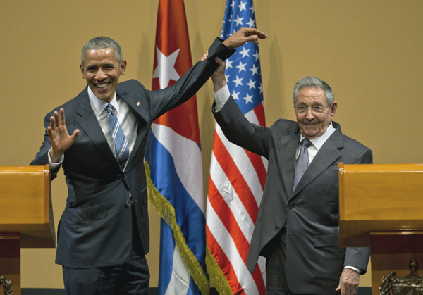 Cuban President Raul Castro lifts up the arm of President Barack Obama at the conclusion of their joint news conference at the Palace of the Revolution, on Monday, in Havana, Cuba (AP photo)