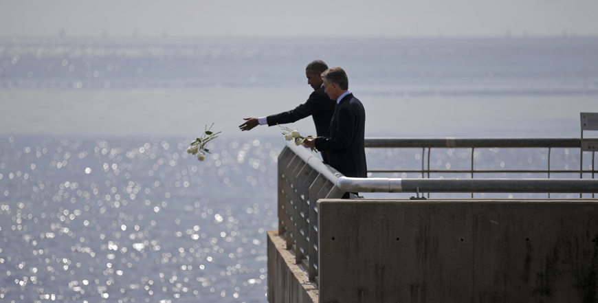 US President Barack Obama throws flowers in the River Plate while visiting with Argentina’s President Mauricio Macri (right) the Parque de la Memoria (Remembrance Park) where they honoured victims of Argentina’s Dirty War on the 40th anniversary of the 1976 coup that initiated that period of military rule, on Thursday (Reuters photo)