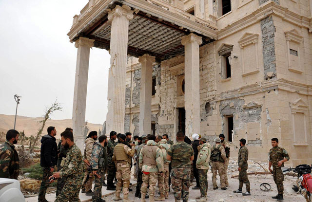 In this photo released on Thursday by the Syrian official news agency SANA, Syrian government soldiers gather outside a damaged palace in Palmyra, central Syria (AP photo)