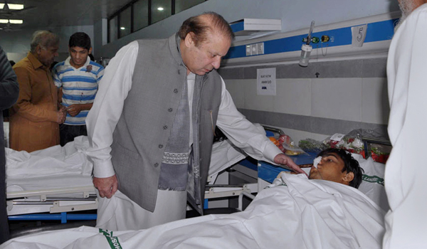 In this photo released by Press Information Department, Pakistan's Prime Minister Nawaz Sharif talks to an injured victim of Sunday's suicide bombing during his visit to a local hospital in Lahore, Pakistan, on Monday (AP photo)
