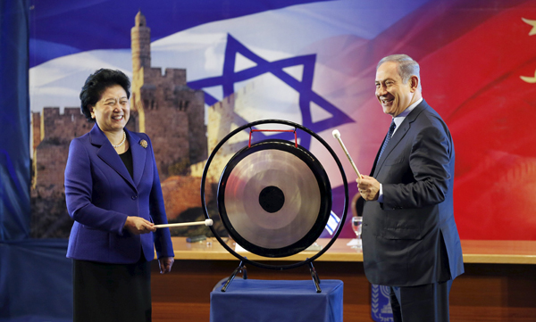 Israeli Prime Minister Benjamin Netanyahu (right) and Chinese Vice Premier Liu Yandong strike a gong during their joint news conference in Occupied Jerusalem on Tuesday (Reuters photo)