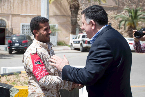 Unity government head Fayez Sarraj (right) shakes hands with a soldier during a tour of Martyrs' Square in Tripoli, Libya, on Friday, in this handout photo provided by the Office of Information (Reuters photo)