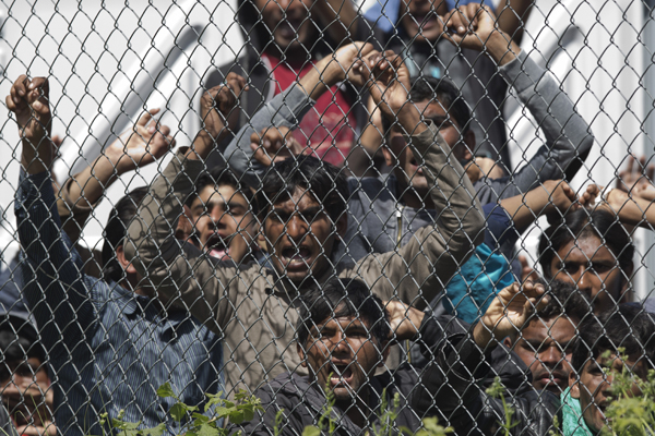 Migrants, most of them from Pakistan, protest against the EU- Turkey deal about migration, inside the entrance of Moria camp in the Greek island of Lesbos, on Tuesday (AP photo)