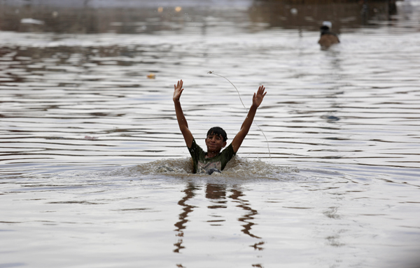 A boy swims in floodwaters on a rainy day in Sanaa, Yemen, Wednesday (AP photo)