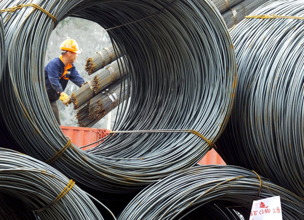 An employee unloads steel products at a market in Yichang, Hubei province, China, April 7 (Reuters photo)