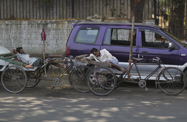 Indian rickshaw pullers rest under the shade of a tree on a hot summer day in Hyderabad, India, on Wednesday (AP photo)