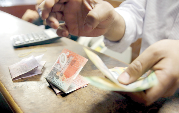 An employee counts Australian dollar banknotes at an exchange office in downtown Cairo, Egypt, on Tuesday (Reuters photo)