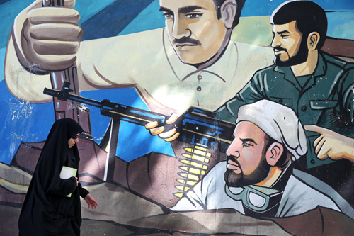 An Iranian woman walks past a mural in a sidewalk in downtown Tehran, Iran, on Saturday (AP photo)