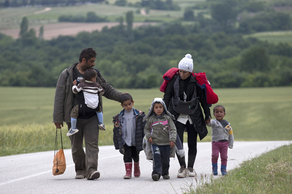 A family walk on their way to Idomeni camp, Greece, after a group of migrants and refugees tried to cross the former Yugoslav Republic of Macedonia’s border, on Wednesday (AP photo)