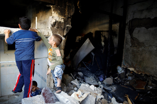 Children play inside a devastated house struck by rocket fire from Syria in Turkey's southeastern border town of Kilis May 10 (Reuters photo)