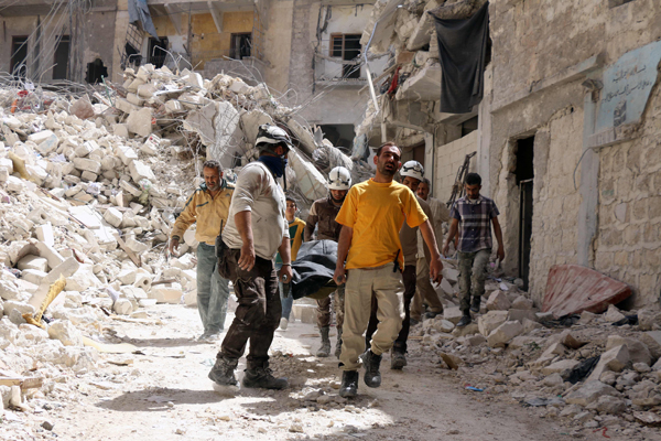 Syrian Civil Defence workers evacuate a body following a regime air strike, on Tuesday (AFP photo)