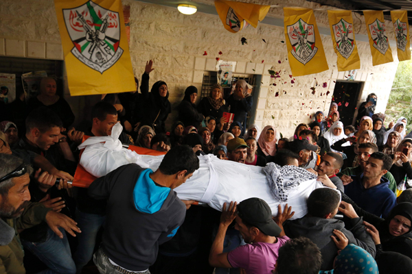 Palestinian mourners carry the bodies of Maram Abu Ismail, 23, and her brother Ibrahim Taha, 16, who were shot dead by Israeli forces last month at the Qalandiya checkpoint after attempting to carry out a stabbing attack, during their funeral in the West Bank village of Qatanna, on Monday (AFP photo)