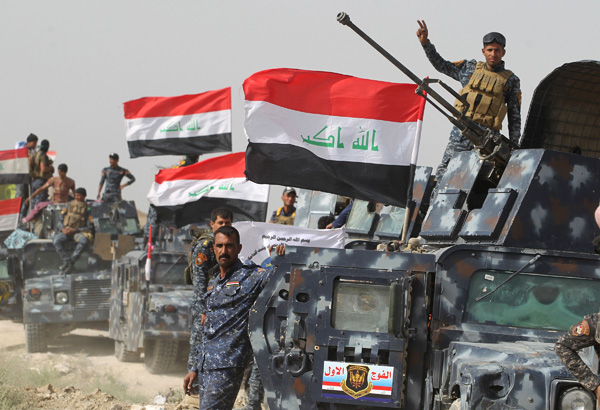 Iraqi pro-government forces gather in Al Shahabi village, east of Fallujah, on Tuesday (AFP photo)