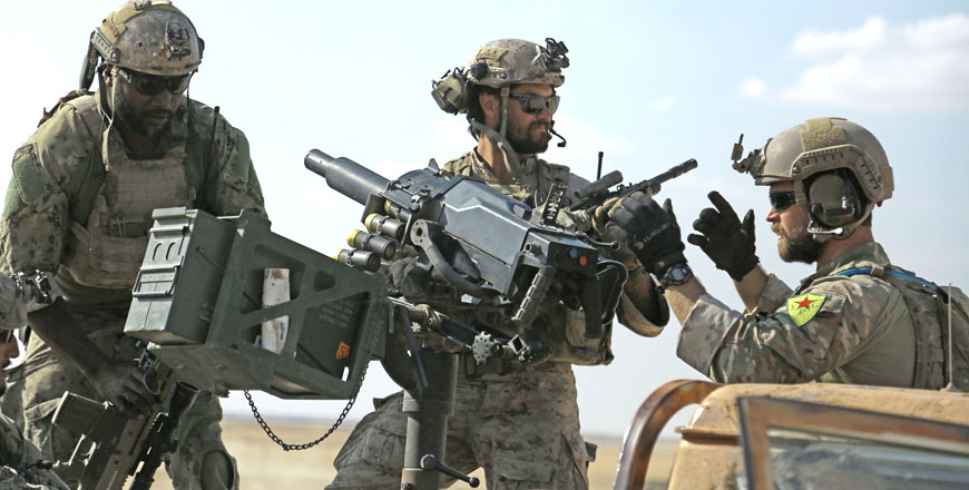 This photo taken on May 25 shows men in uniform identified by Syrian Democratic Forces as US special operations forces as they ride in the back of a pickup truck in the village of Fatisah in the northern Syrian province of Raqqa (AFP photo)