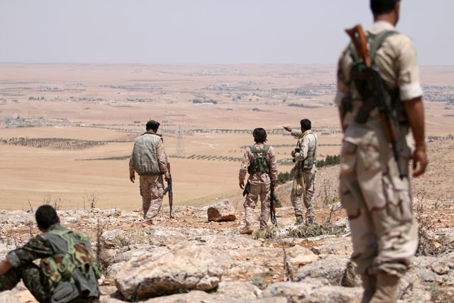 Fighters of the Manbij Military Council take an overwatch position in the southern rural area of Manbij, in Aleppo Governorate, Syria, on Wednesday (Reuters photo)