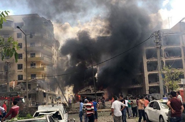 People watch after a Kurdish rebel suicide bomber detonated an explosives-laden vehicle outside a police headquarters in Midyat, near Turkey’s border with Syria, Wednesday, killing four people, according to Turkish officials (AP photo)