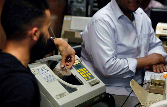An employee counts Egyptian 50 pound notes at an exchange office in downtown Cairo, Egypt, April 19 (Reuters photo)